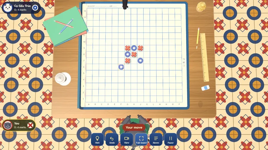 Early in a game: red X marks and blue O marks on a 15 by 15 notebook grid, seen from straight above.