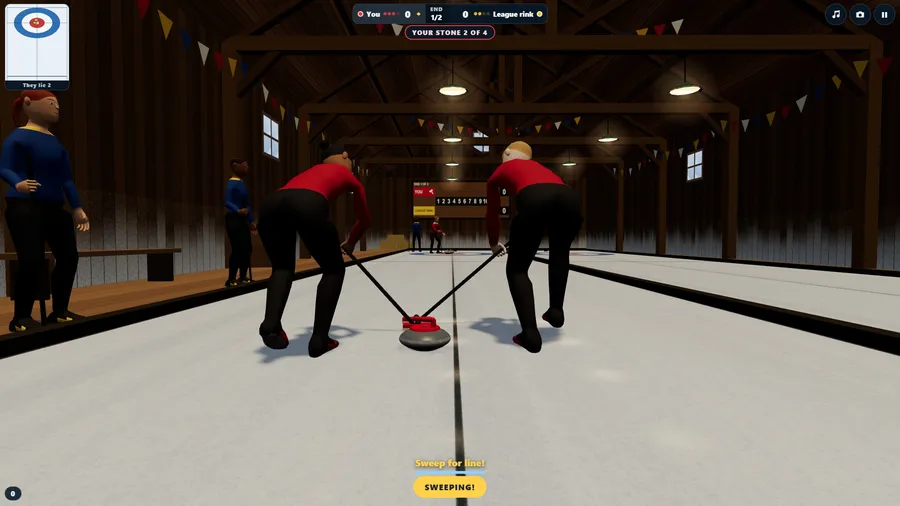 Close behind a running stone in the barn as two sweepers brush the ice in front of it.
