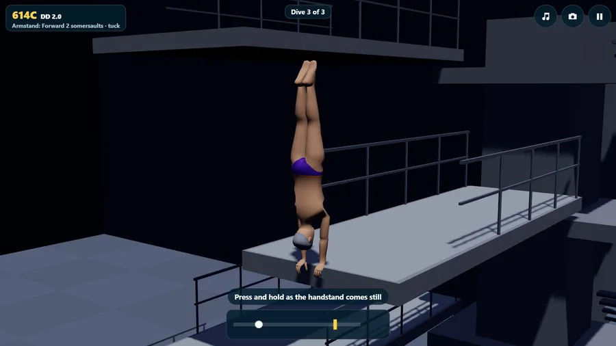 At night in an arena, a diver stands on their hands at the edge of a high platform.