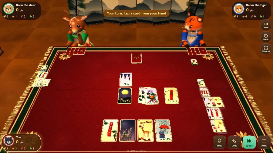 Midgame: captured cards are stacked in neat piles beside the mat, and a banner says it is your turn to tap a card.