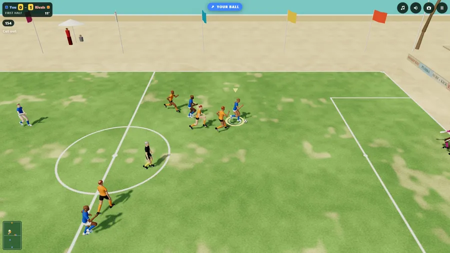 A sandy pitch by the shore from the side: a blue player runs the ball through midfield, orange players chasing.