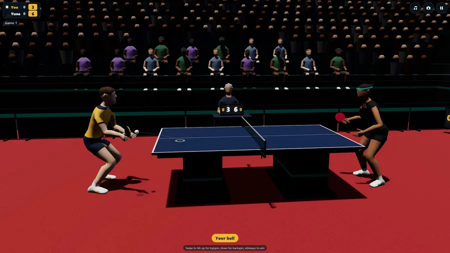 Side on at The Arena: both players crouched at a blue show table on a red mat, the crowd behind.